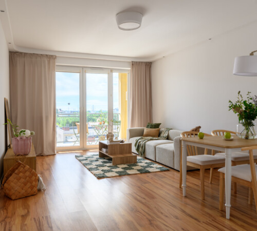 Jasny salon z sofą i stołem po home stagingu mieszkania w Ząbkach